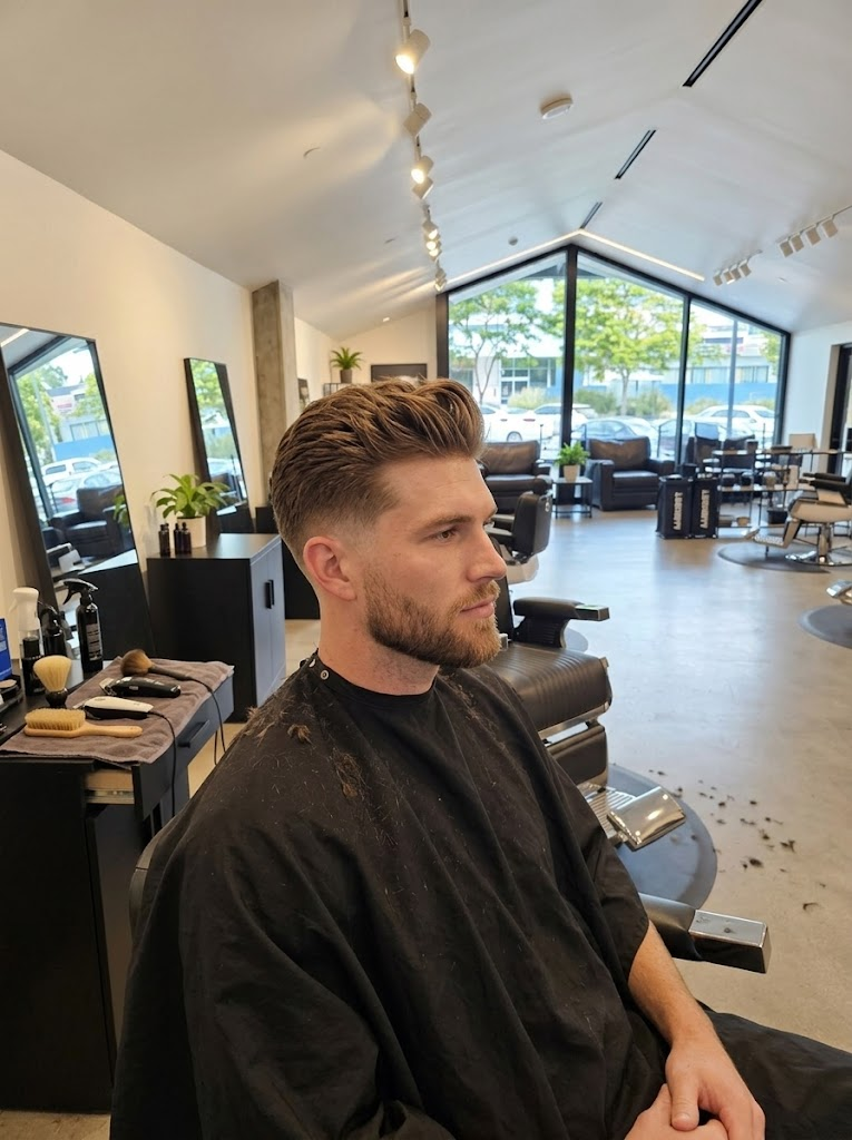 Swept-back haircut with tapered sides and full beard